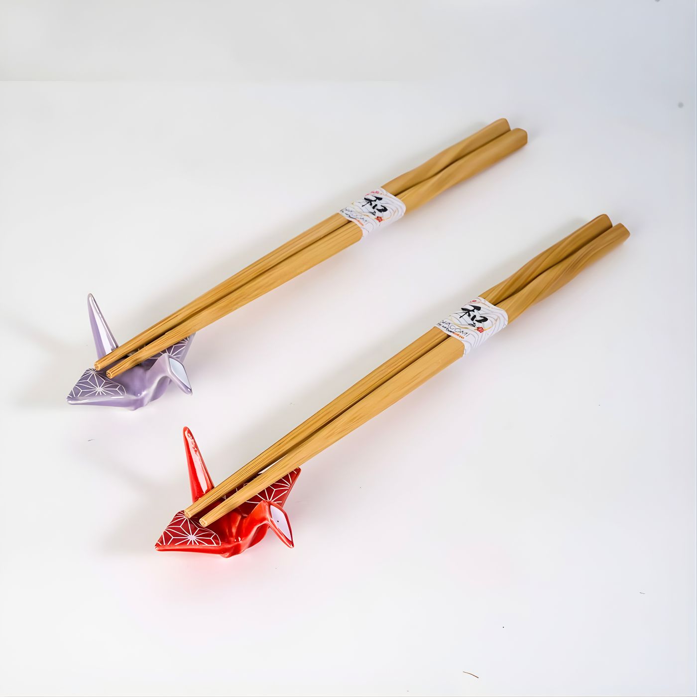 Bamboo chopsticks with smooth twisted design for balanced grip featuring ceramic chopstick rest shaped like origami crane in red and purple