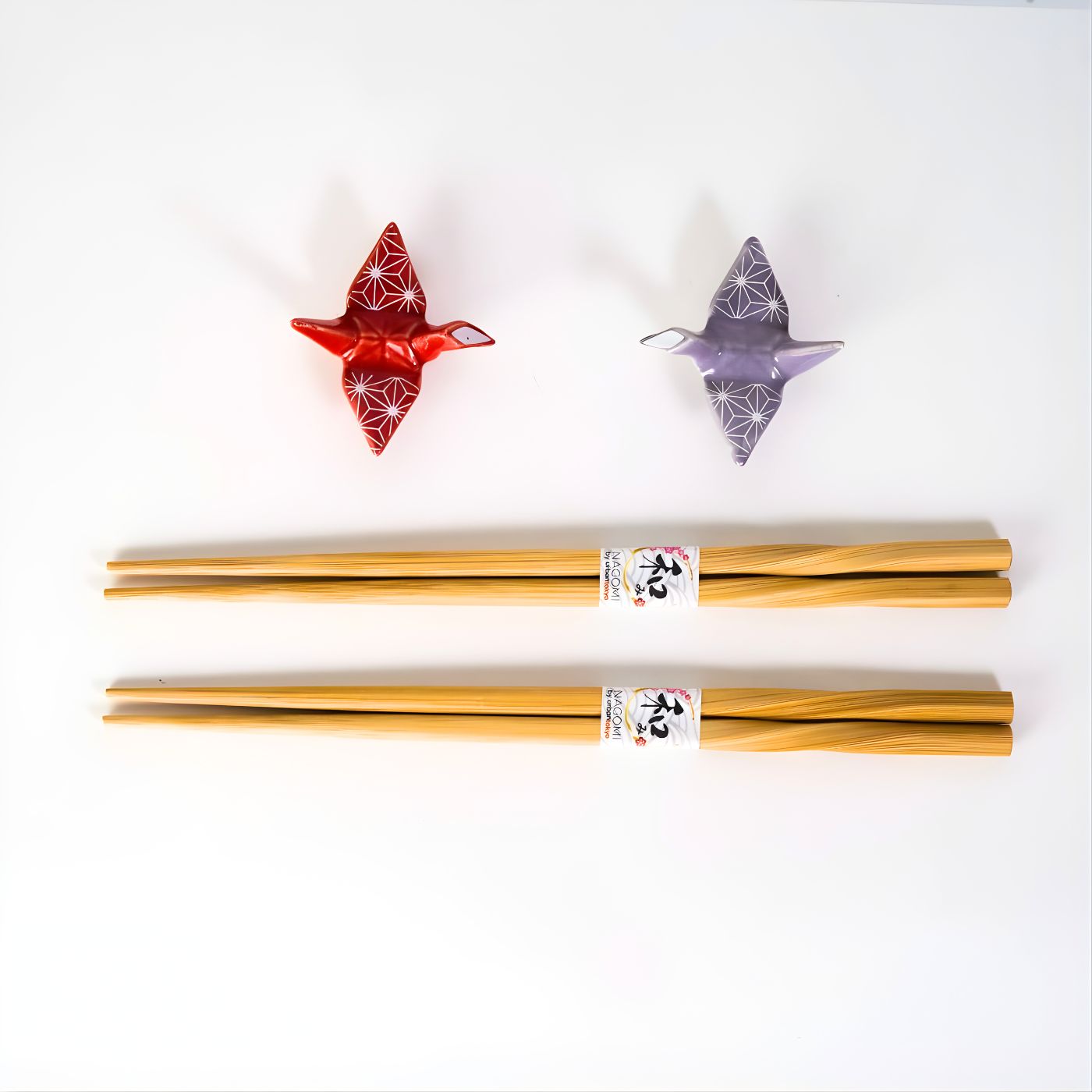 2 pairs of bamboo chopsticks and ceramic chopstick rest shaped like origami crane in red and purple