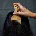 Close-up of combing hair with eco friendly bamboo hair comb