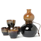 Black and brown Japanese sake set with bottle and four ceramic cups