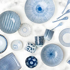 Ceramic teacups in blue and white styled with other dinnerware pieces from the same collection