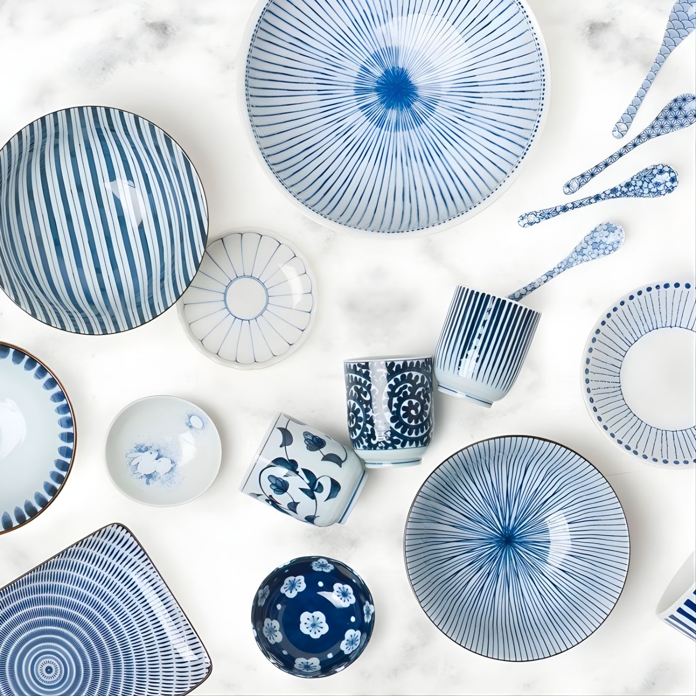 Ceramic teacups in blue and white styled with other dinnerware pieces from the same collection