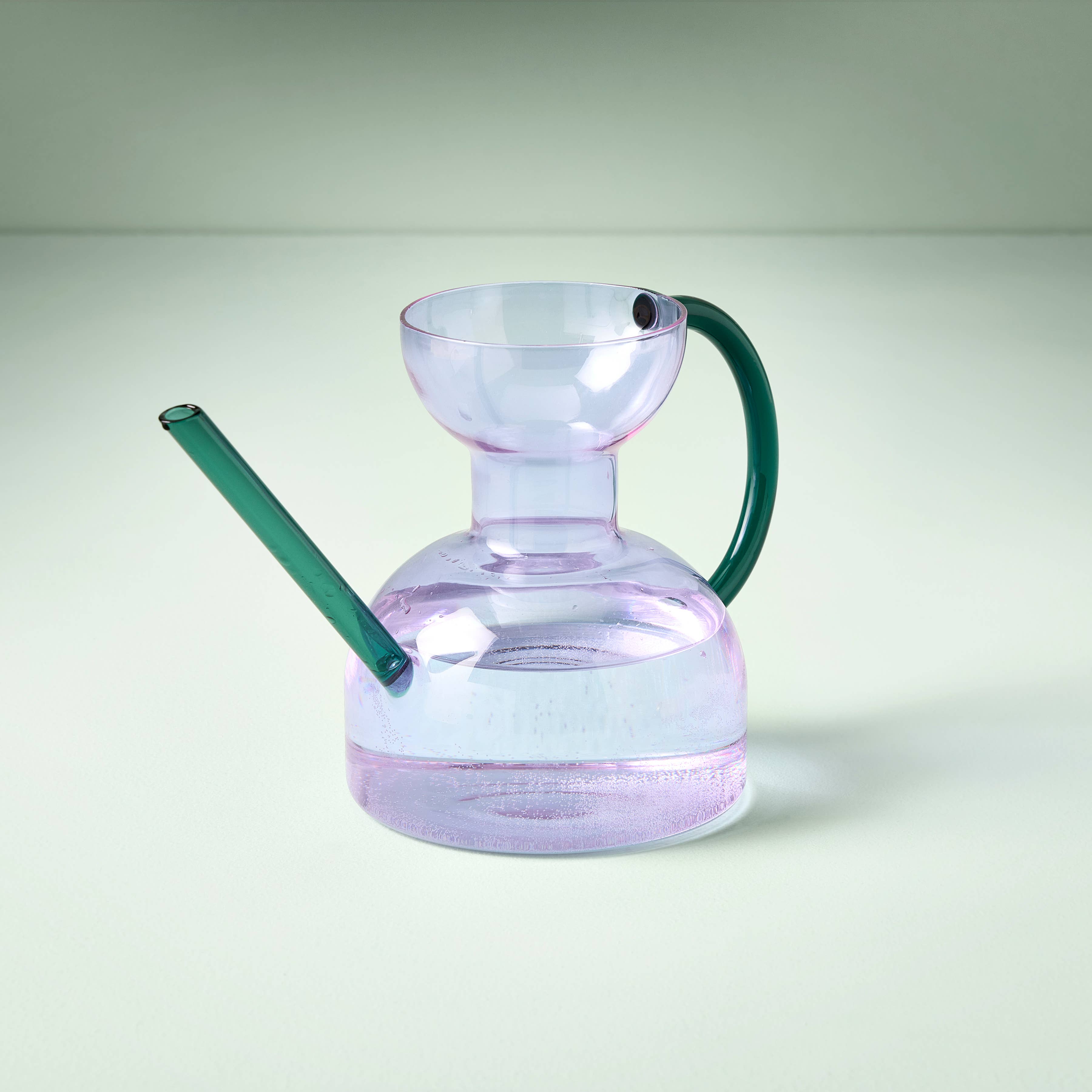 Clear glass purple watering can with water