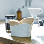 Ceramic paper filter stand styled on kitchen counter with pour over coffee setup