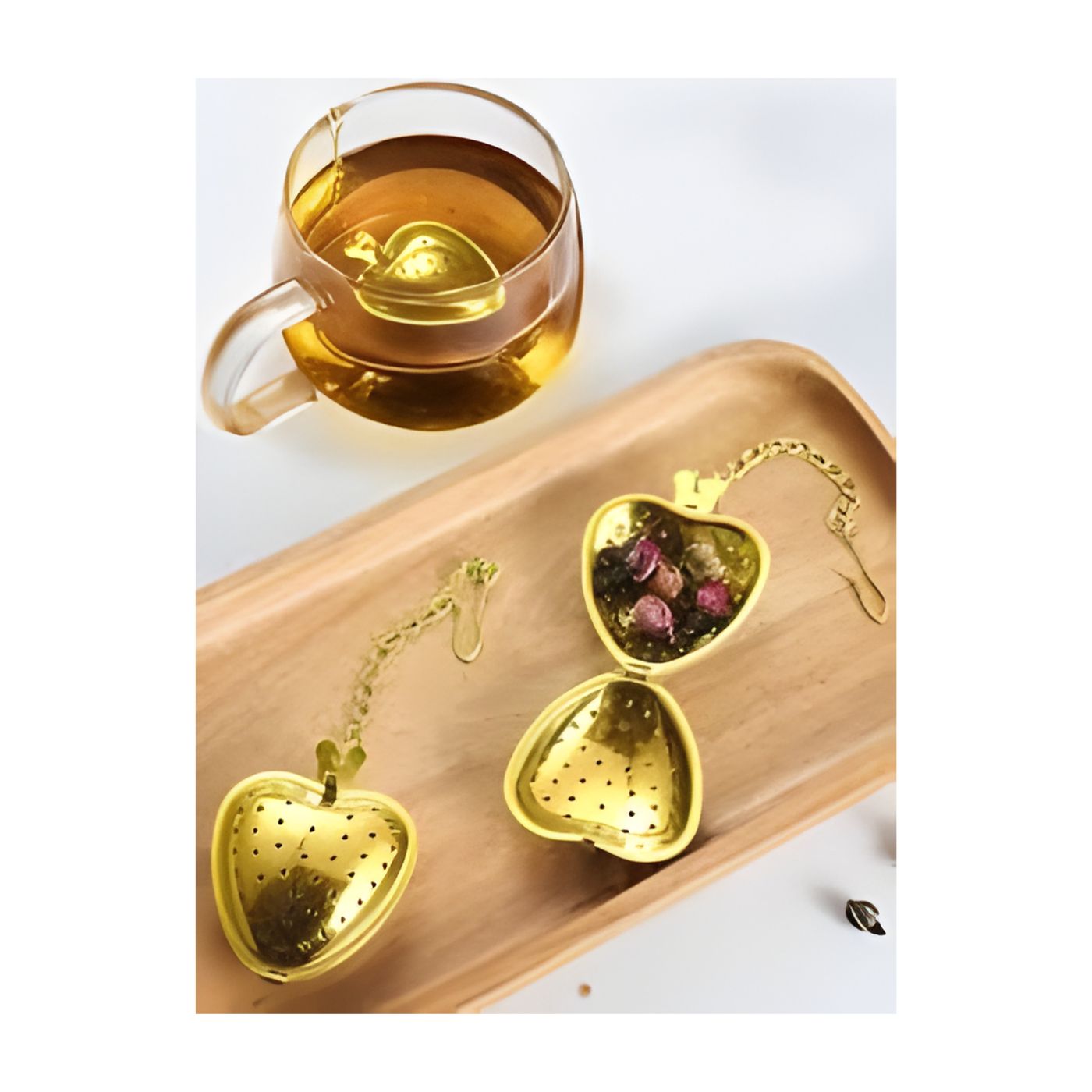 Gold heart tea strainer steeping in glass teacup