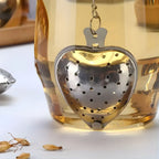 Heart tea strainer steeping loose leaf tea in front of glass tea cup
