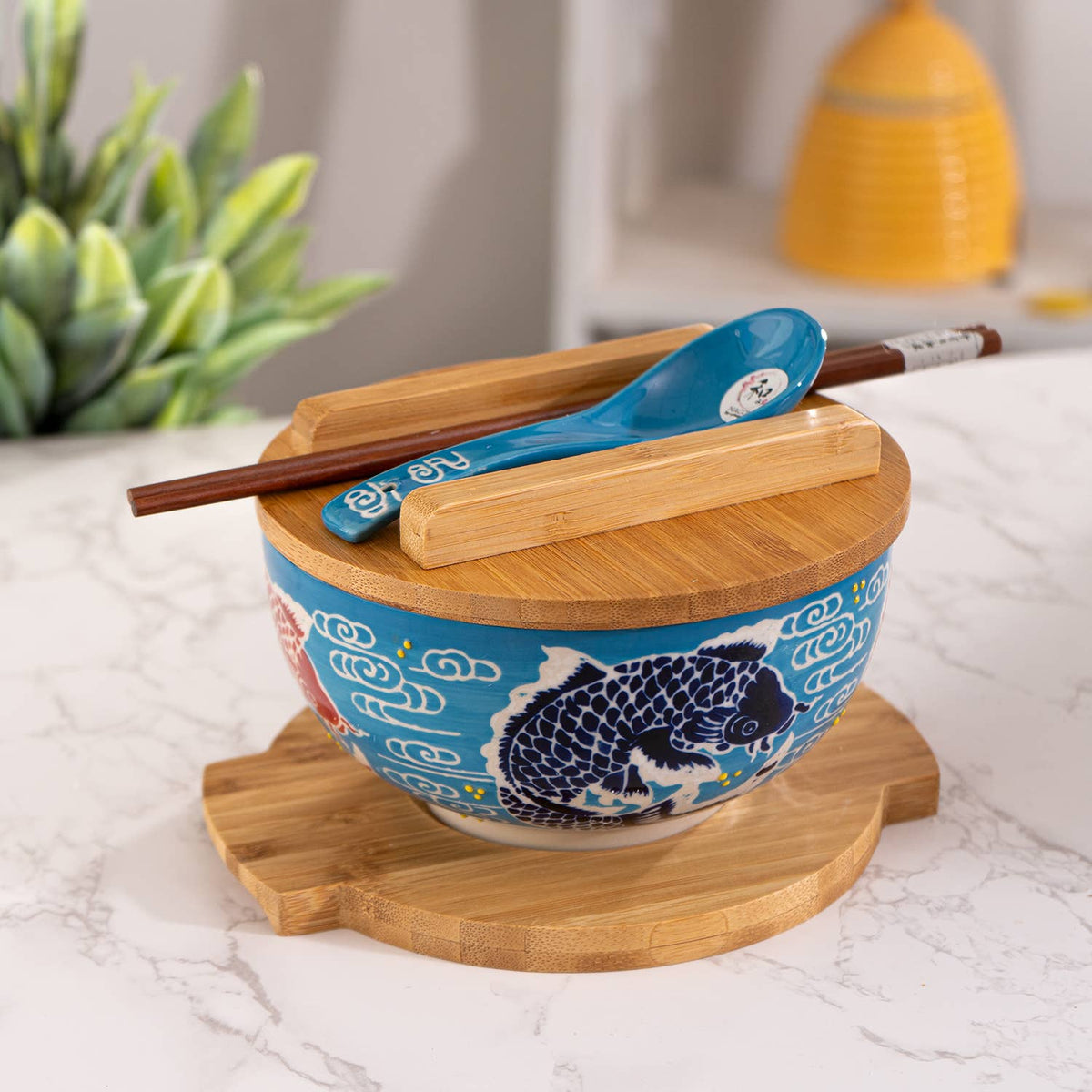 Turquoise koi fish bowl with porcelain spoon and bamboo trivet