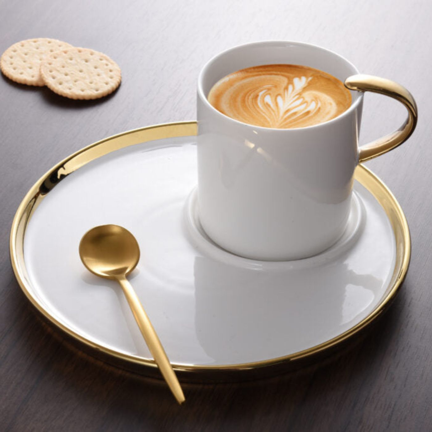 Cappuccino cup and saucer filled with cappuccino and cookies