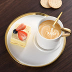 Cappuccino cup and saucer set in white porcelain and gold accents with cake and cappuccino