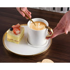 A cup of cappuccino and a piece of cake served in the Pampa Bay cappuccino cup and saucer gift set