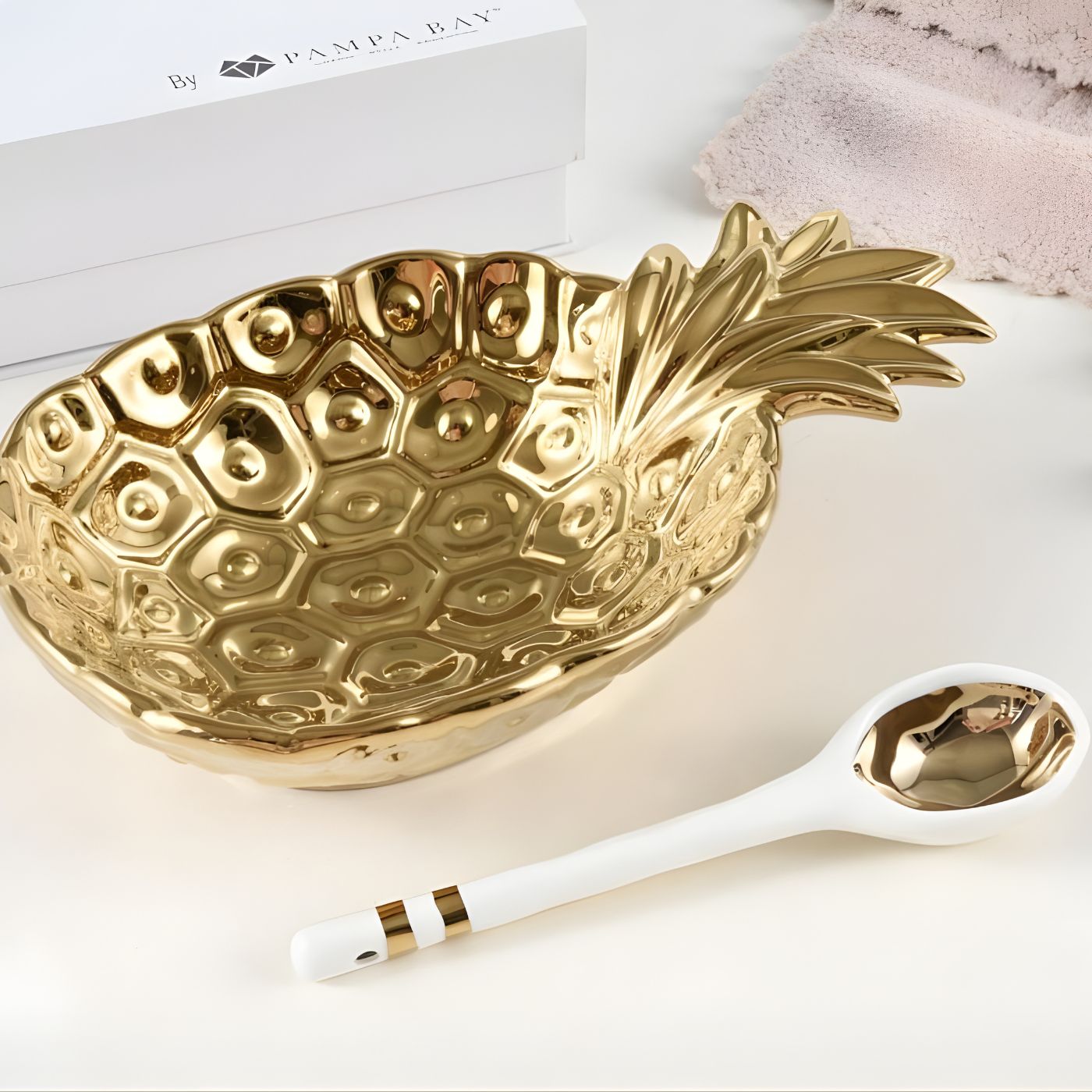 Gold pineapple bowl and white porcelain spoon with gold accents