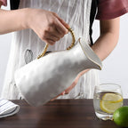 Porcelain jug with gold trim water pitcher pouring water