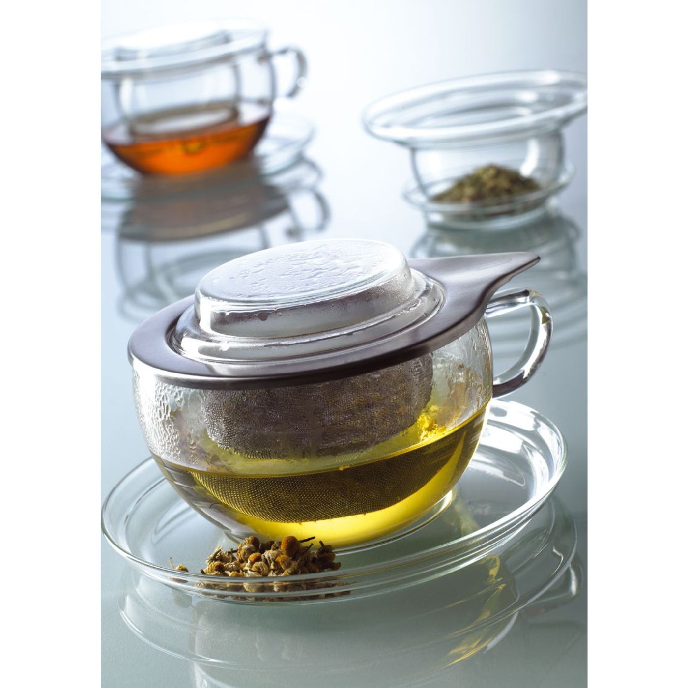 Loose leaf tea steeping in glass cup with steel strainer