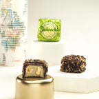 Close-up of pistachio praline filling inside dark chocolate shell