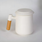 Porcelain tea mug with infuser and natural wood accent handle
