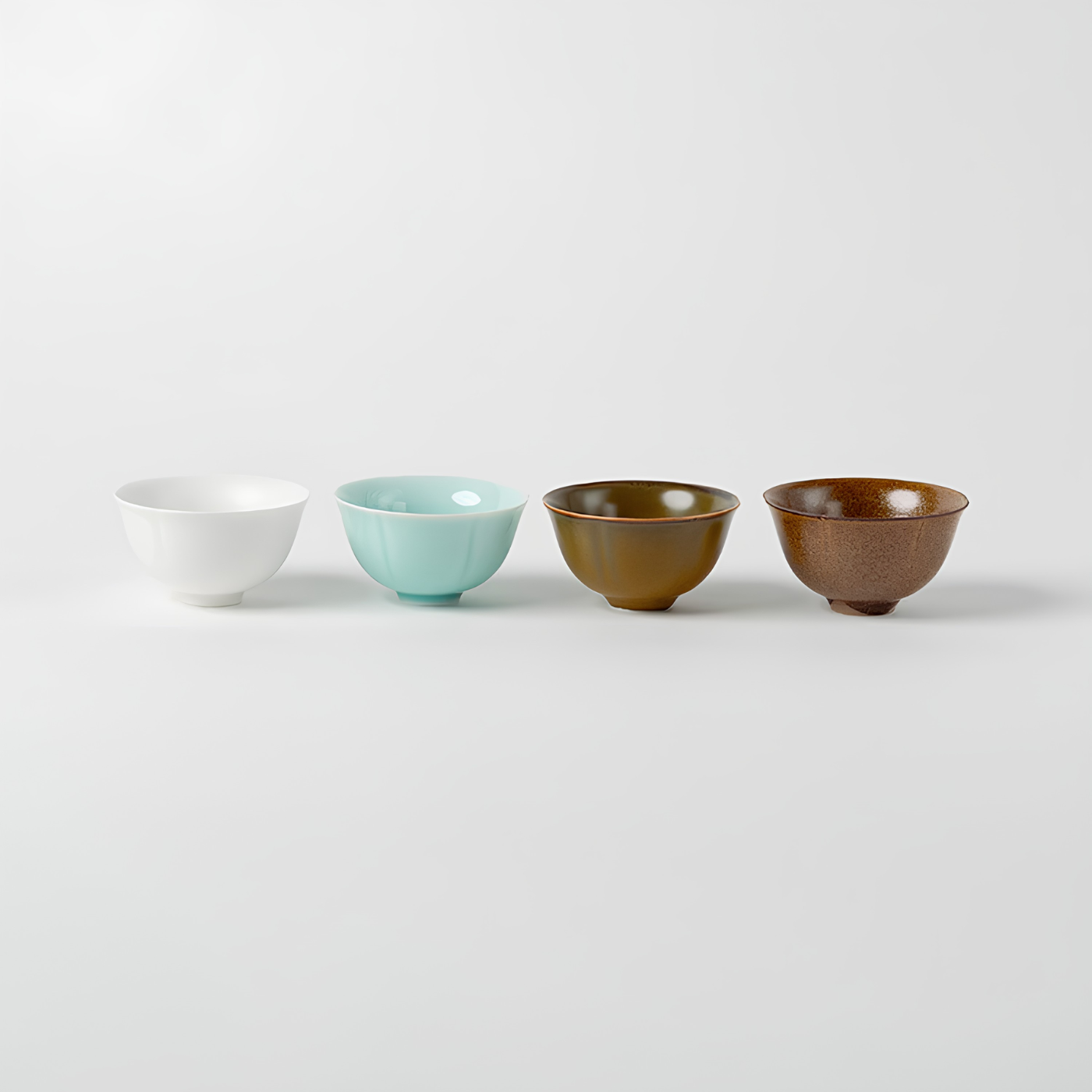 Four Taiwanese ceramic tea cups in different glaze colors