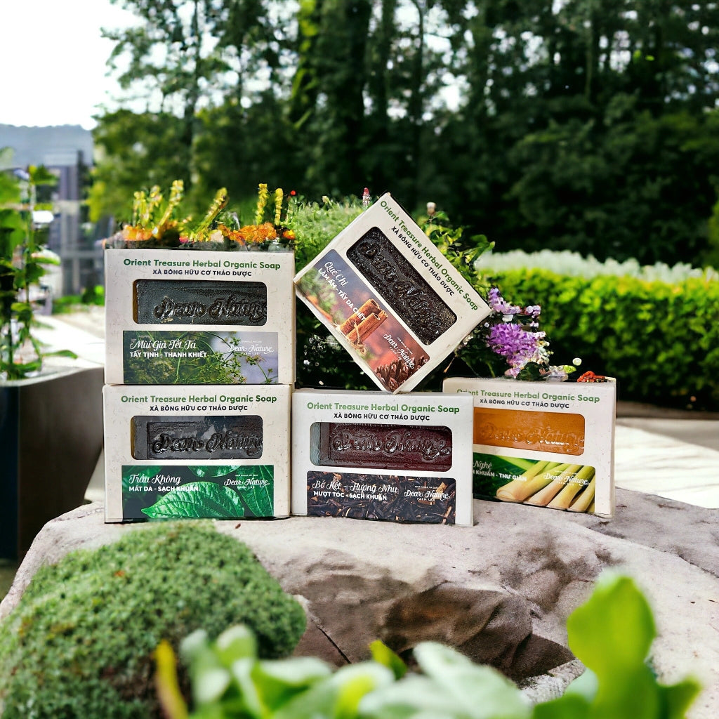 Dear Nature Orient Treasure Herbal Organic Soap collection – natural handmade soaps from Vietnam featuring Tet Scent, Betel Leaf, Lemongrass, and other herbal varieties displayed outdoors