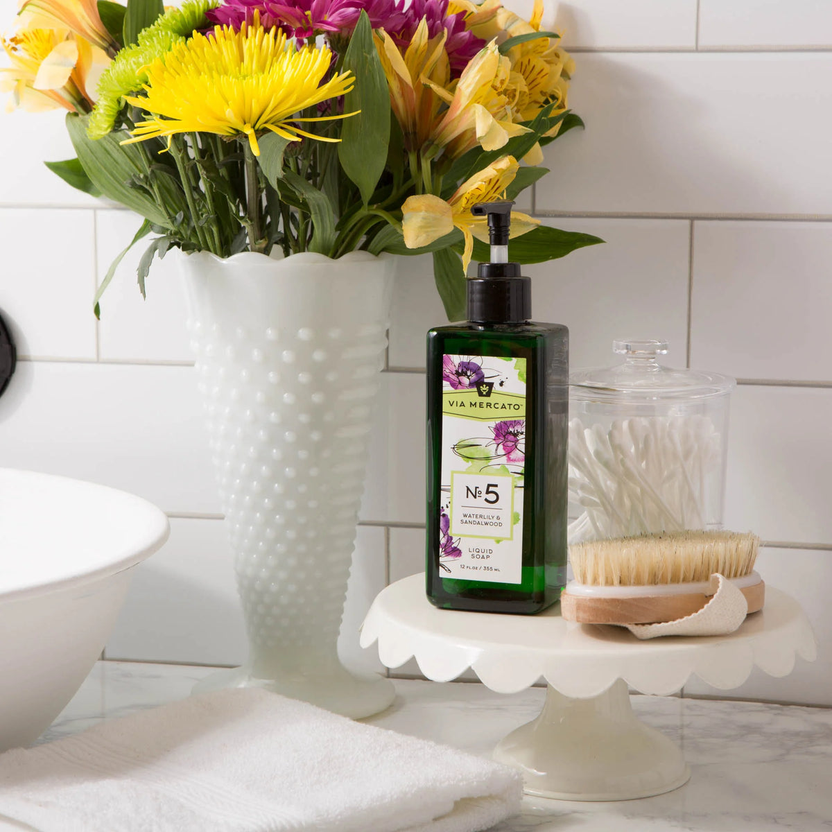 Via Mercato Waterlily & Sandalwood hand soap beside a bathroom sink