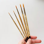 Five wooden watercolor paintbrushes with synthetic bristles